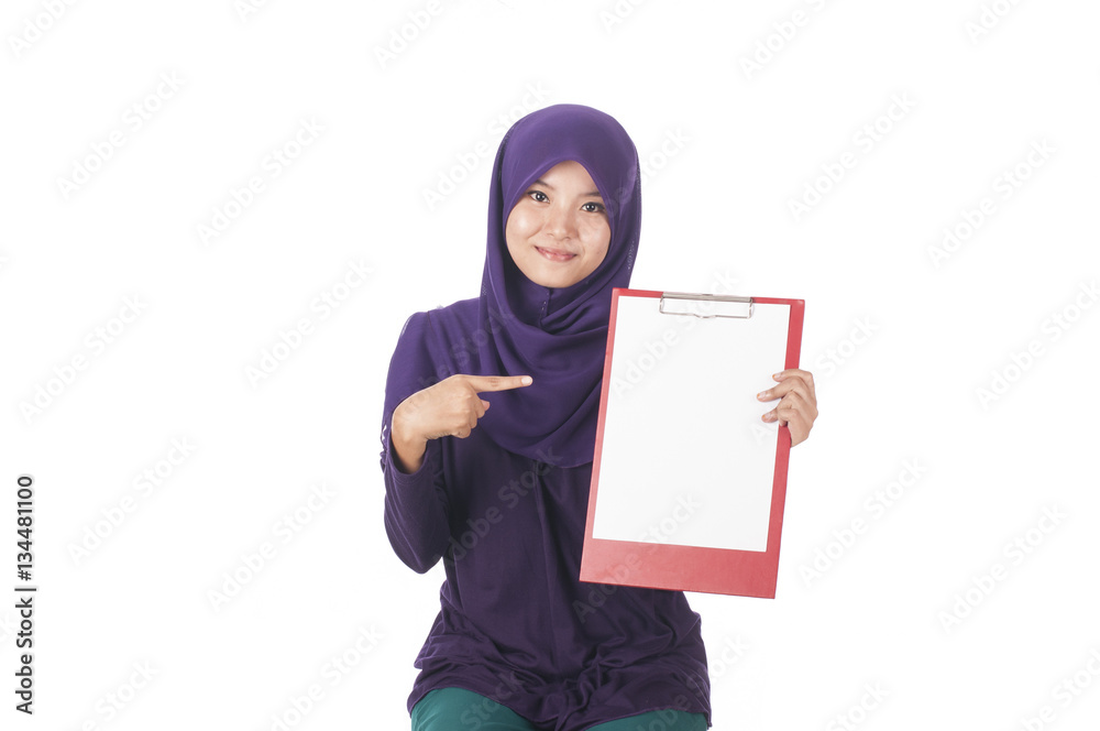 Young muslimah woman smile and point to the left while holding text space card Young muslimah woman smile and point to the left while holding text space card