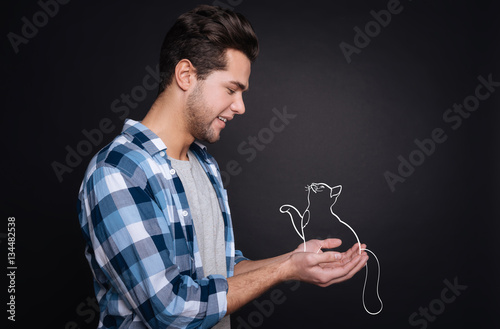 Handsome young man holding a kitten.