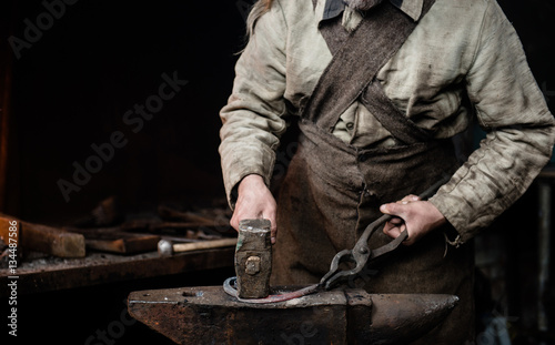 rustic blacksmith forges item on the anvil