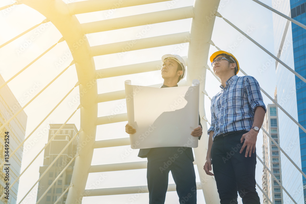 Young Male Architects Discussing with Businessman at Constructio