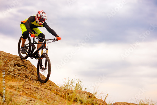 Professional Cyclist Riding the Bike Down Rocky Hill. Extreme Sport Concept. Space for Text. © Maksym Protsenko