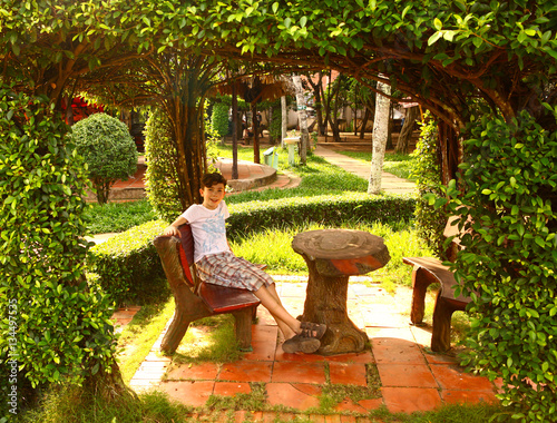 teen boy in green percola with table and bench photo