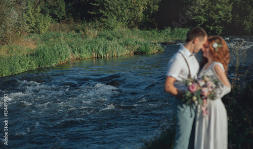 Bride and groom on the lake. Wedding in rustic style, boho