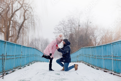 Marriage proposal. Man hold engagement ring at red box in his ha
