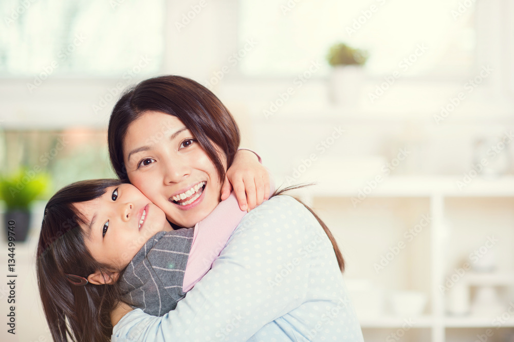 Portrait of happy japanese mother hugging with her cute little d Portrait of happy japanese mother hugging with her cute little d