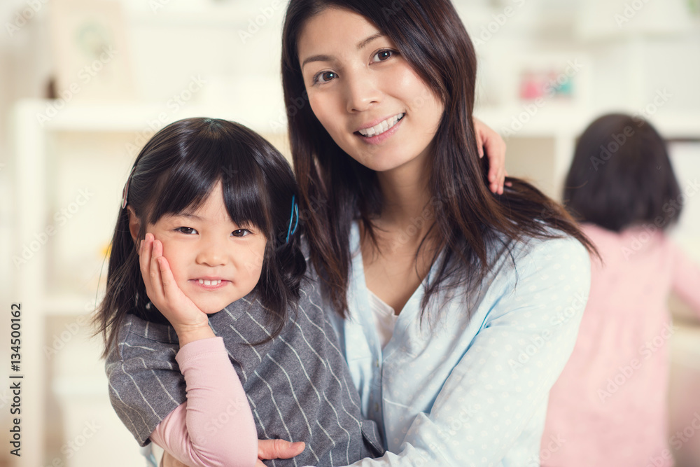Portrait of happy japanese mother hugging with her cute little d Portrait of happy japanese mother hugging with her cute little d