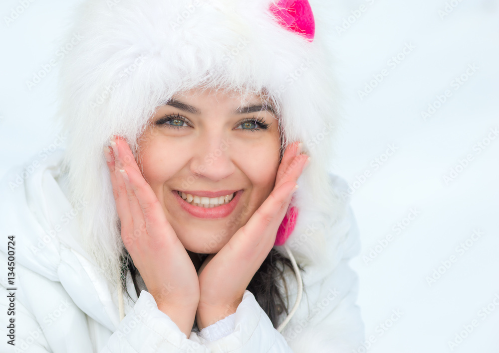 Winter young woman portrait. Beauty Joyful Model Girl touching her face skin and laughing, having fun in winter park Winter young woman portrait. Beauty Joyful Model Girl touching her face skin and laughing, having fun in winter park