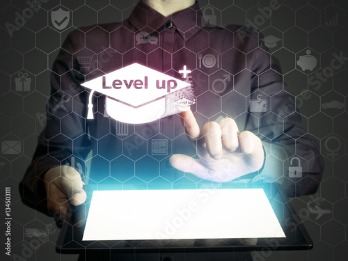 Concept of online education. Person (man or woman) touches to graduation hat icon with title 'level up'. He holds tablet pc, that contains a many different online services.