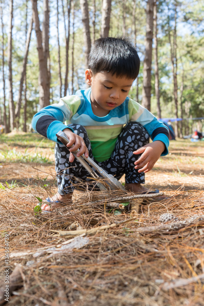 Asian little boy playing in a forest Asian little boy playing in a forest