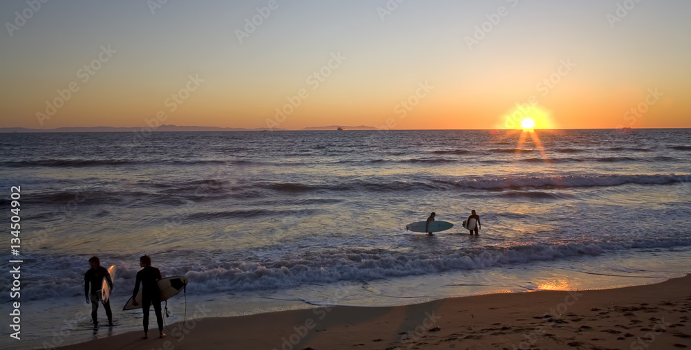 Surfers enjoy the sunset along Southern California's Pacific Ocean Coastline