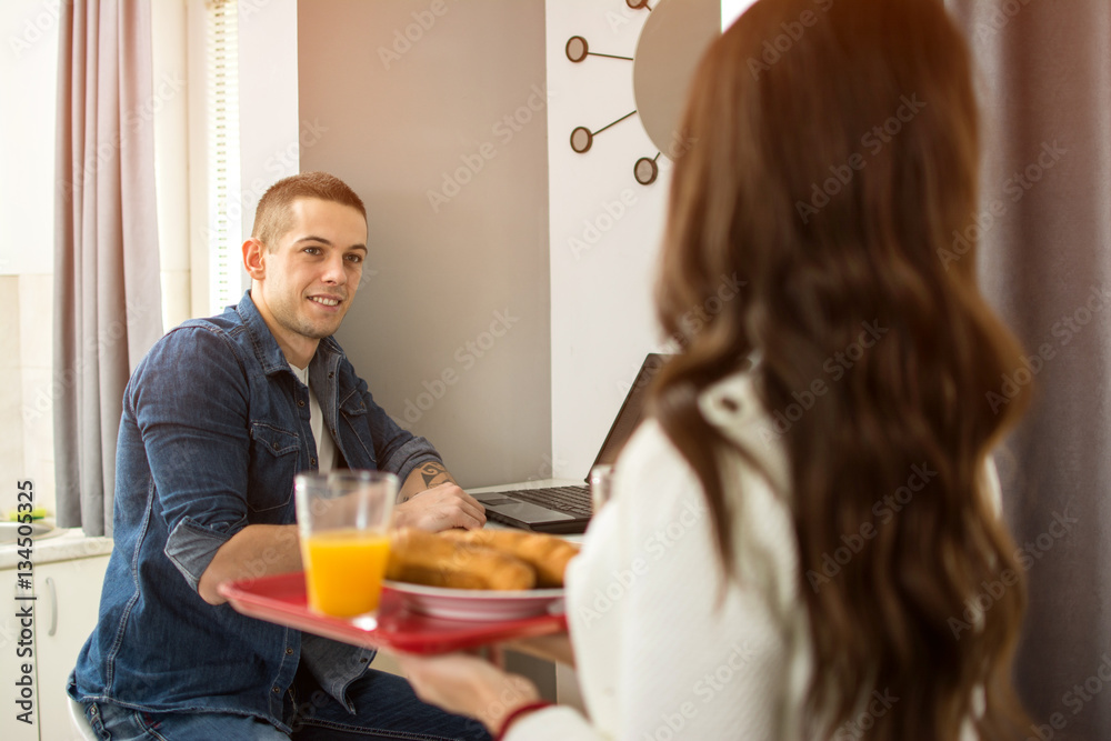Girlfriend bringing breakfast to his boyfriend.