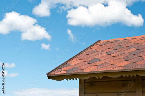 Edge of roof of a wooden cabin on a background of sky