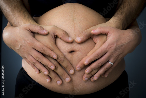 hands holding a pregnant belly
