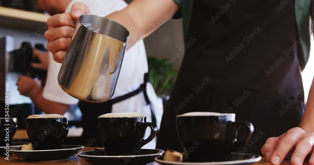 Waiter making coffee at counter in cafe 4k
