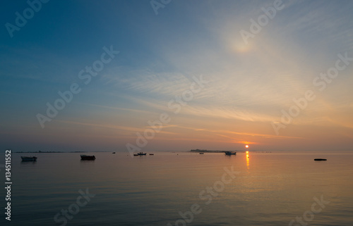 Sonnenaufgang an der bretonischen Küste, zwei Fischer auf ihrem Boot