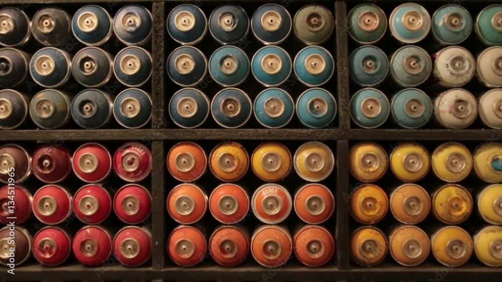 Close up view of the shelf with used multicolored graffiti spray cans. Art, artistic style. Inside shooting. Close up view of the shelf with used multicolored graffiti spray cans. Art, artistic style. Inside shooting.
