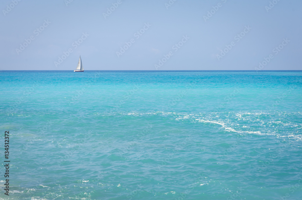 Obraz premium Seascape. The coast of the Ligurian Sea, with turquoise water. Sailboat on the horizon.
