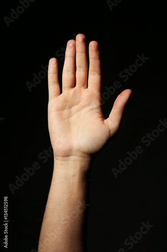 Male hand on a black background
