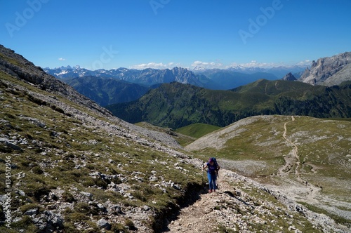 Wanderin bergauf auf Plattkofel im Hintergrund herrliches Dolomiten Panorama