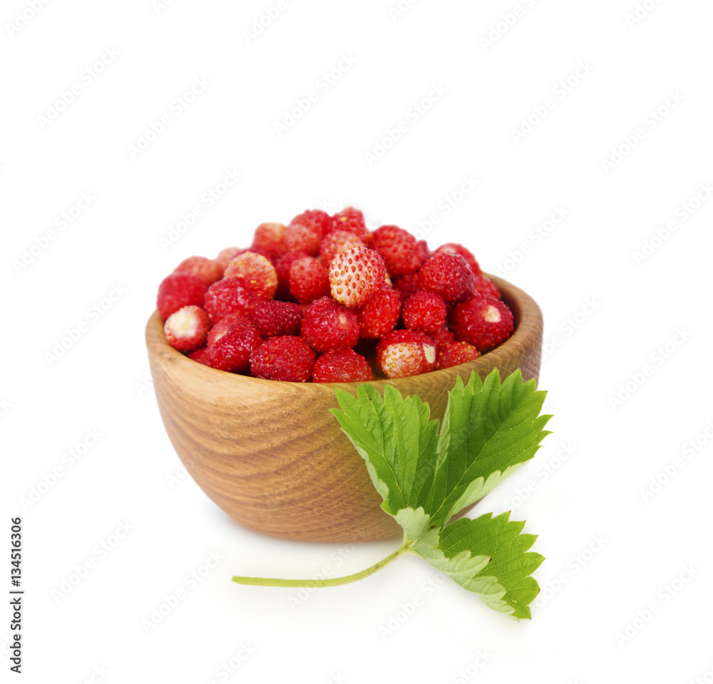 Wild small strawberries in a wooden bowl with leaves. Ripe and tasty strawberries isolated on white background. Sweet and juicy berry with copy space for text. Wild small strawberries in a wooden bowl with leaves. Ripe and tasty strawberries isolated on white background. Sweet and juicy berry with copy space for text.