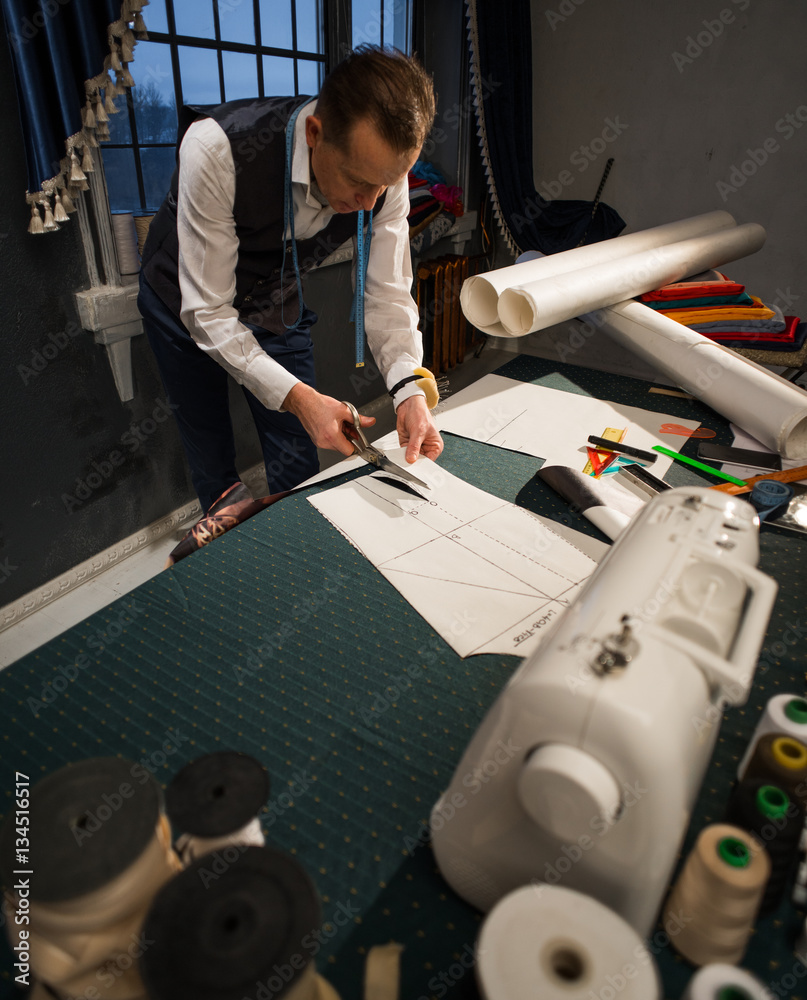 The tailor cuts the pattern of clothing made of paper StockFoto