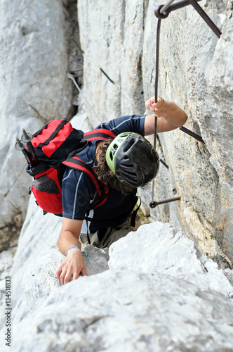 Mountaineer climbing up the steepy mountain in summer. photo