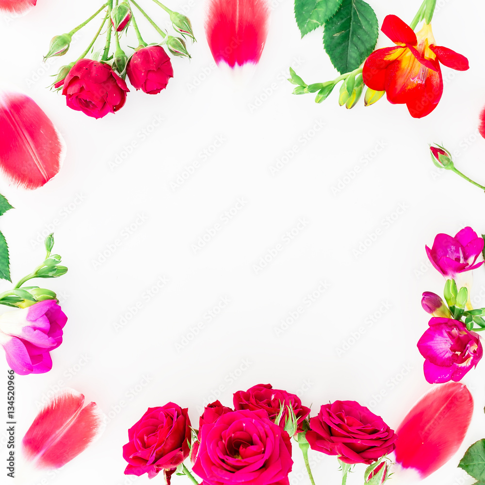 Flat lay frame with red roses and freesia, branches, leaves and petals isolated on white background. Top view
