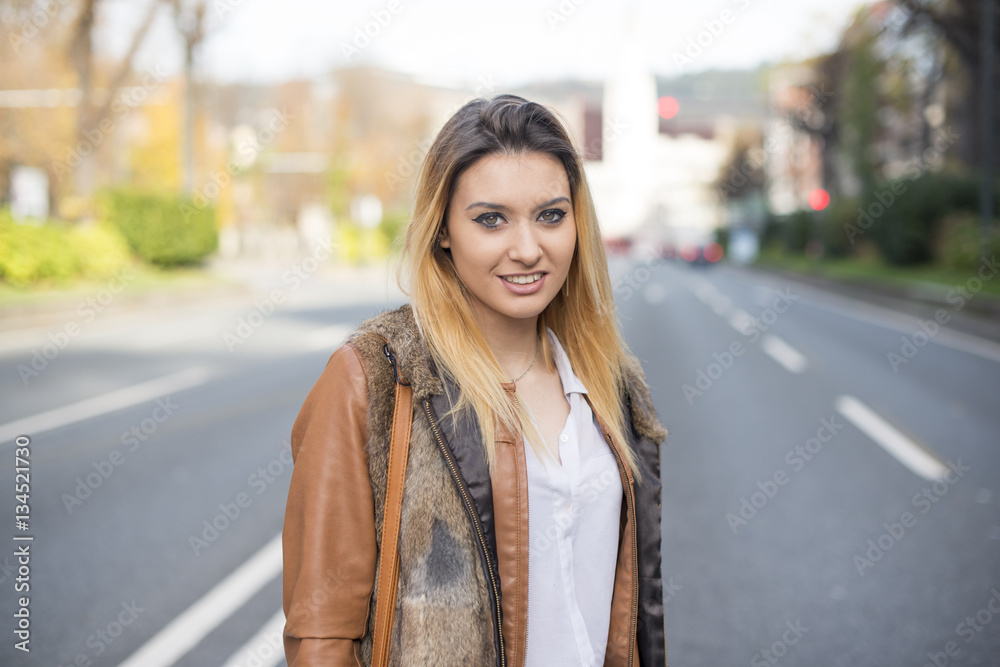 Happy young woman in the street.