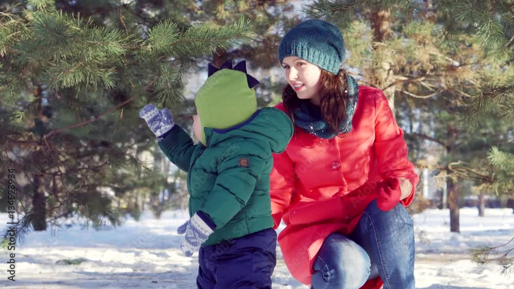 Little boy the kid in the green jacket walking with my mother in winter