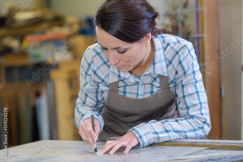 artisan worker drawing round stencil in workshop