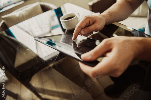 Young successful man sitting in a cafe with cup of coffee