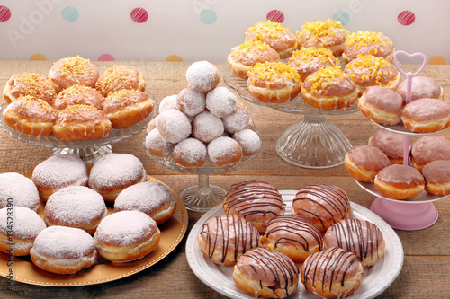 Different types of donuts cakes on wooden table photo
