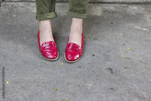 Two feet in red lady shoes over concret