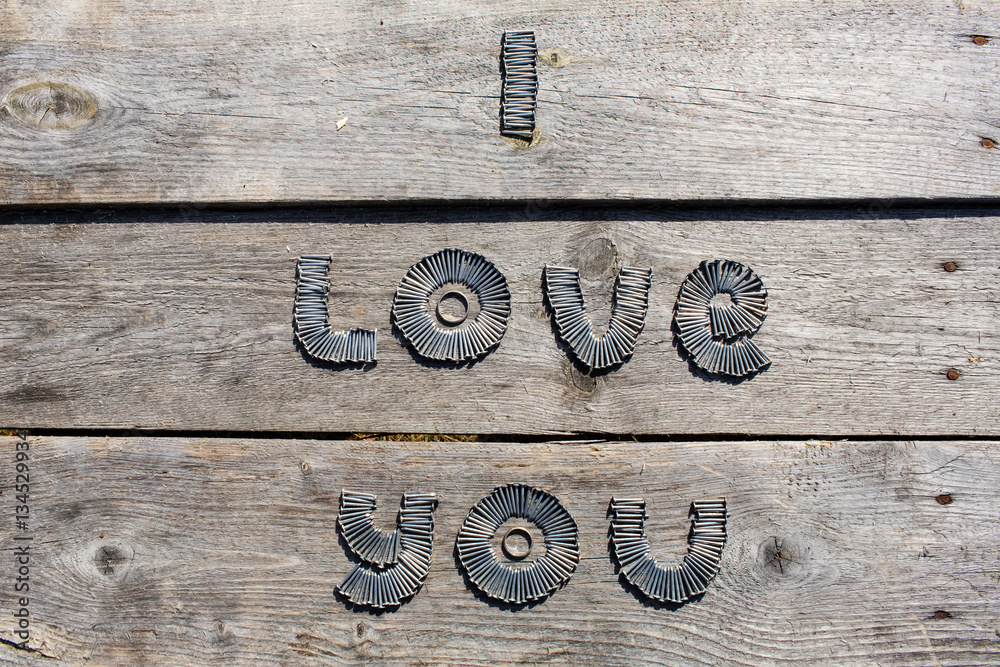 Naklejka Text I LOVE YOU written by metal nails on wooden background