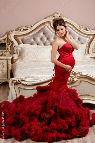 Fashion pregnant woman in evening red dress 