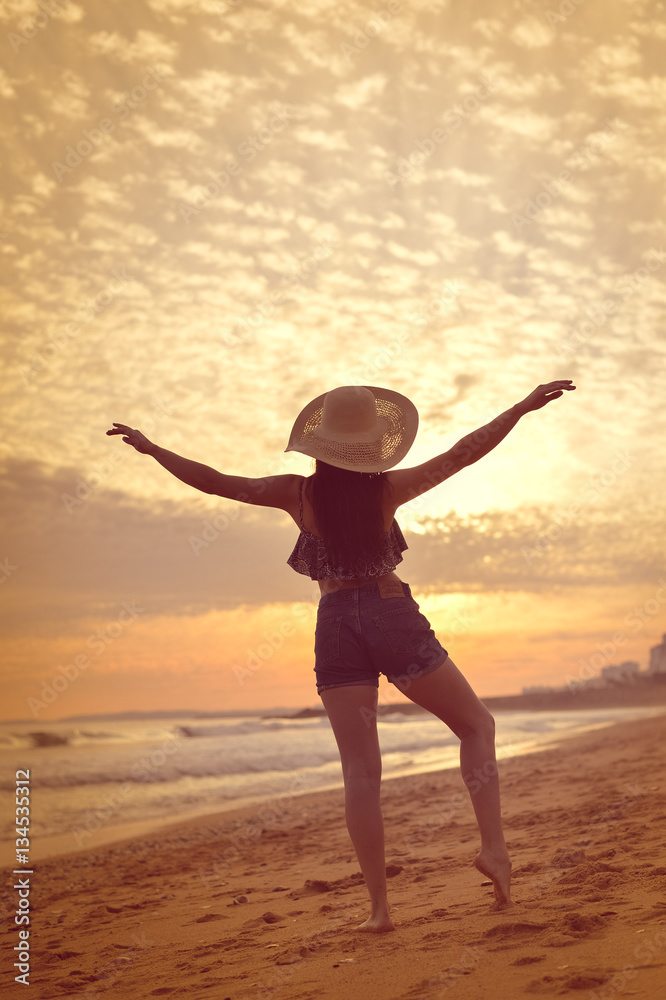 Joyful woman dancing in the sunset on beach background Joyful woman dancing in the sunset on beach background