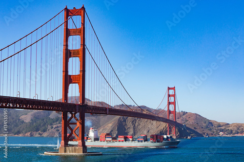 A Freight ship passes below the Golden Gate Bridge in San Francisco, California.