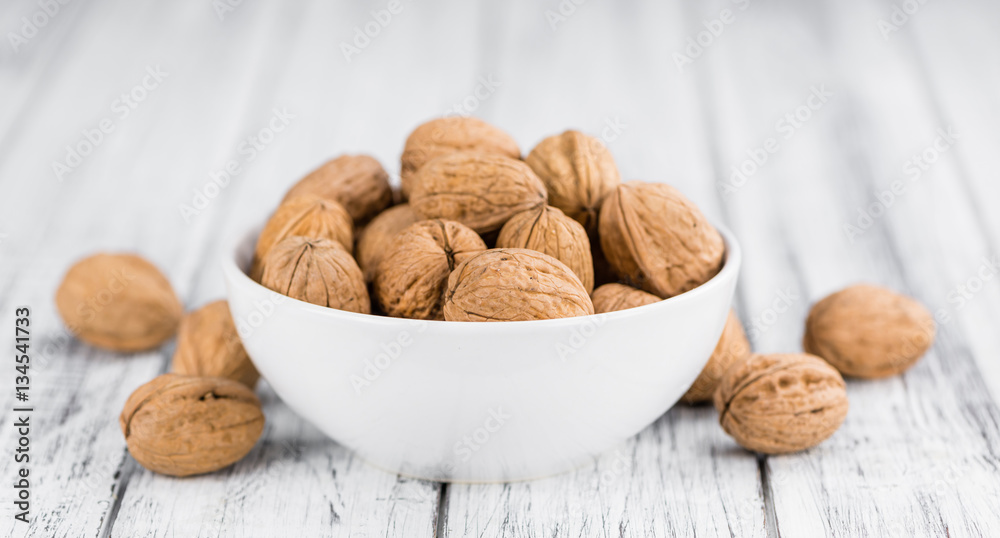 Whole Walnuts on wooden background (selective focus)