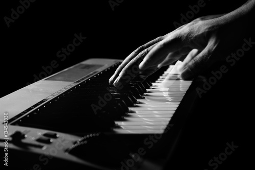 Musician's hand is playing a keyboard