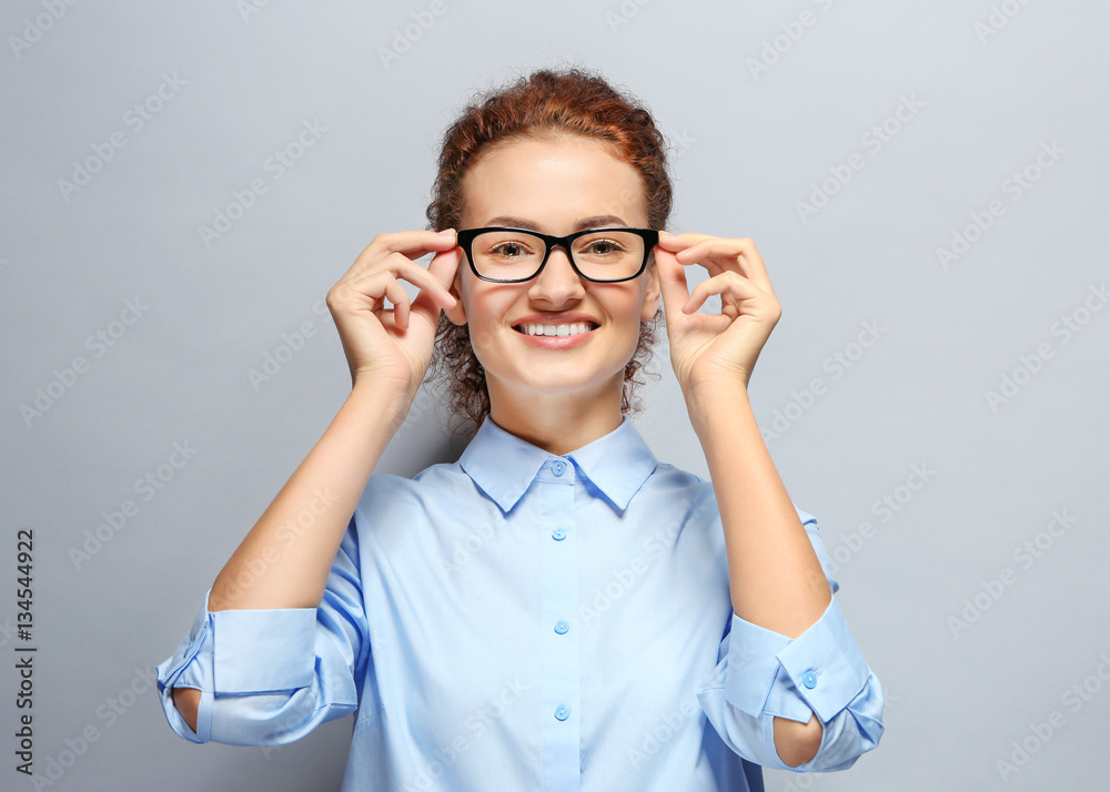 Young woman with spectacles on grey background Young woman with spectacles on grey background