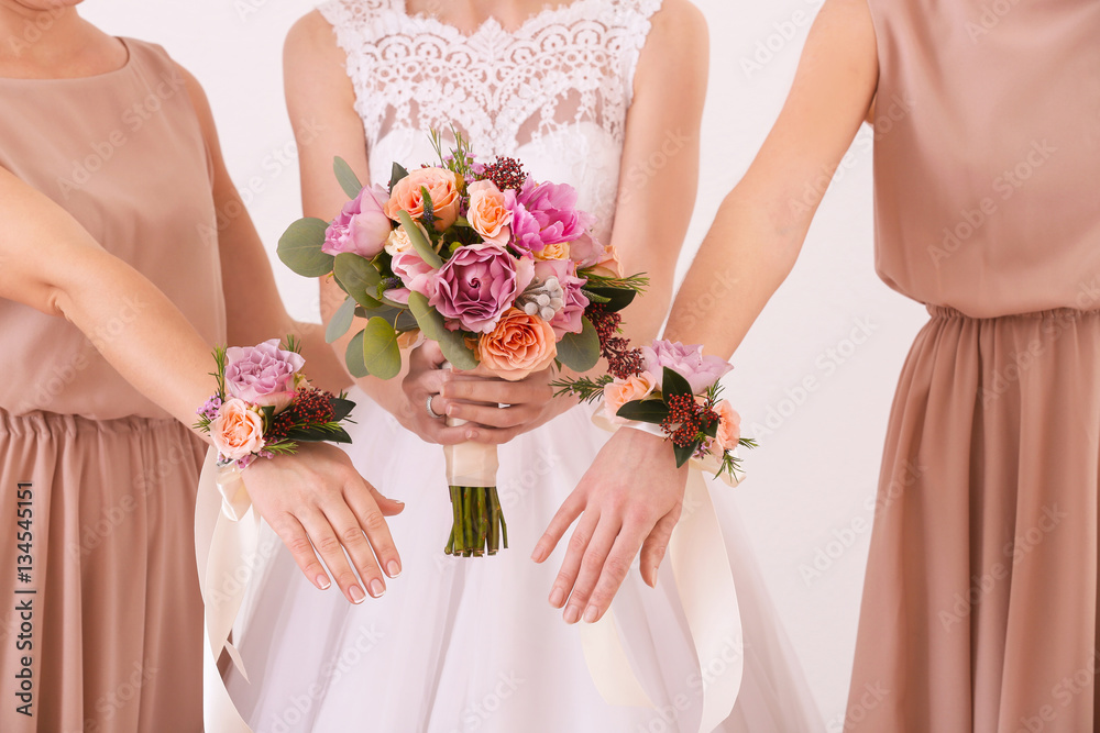 Bride holding wedding bouquet and bridesmaids with beautiful boutonniere, closeup Bride holding wedding bouquet and bridesmaids with beautiful boutonniere, closeup
