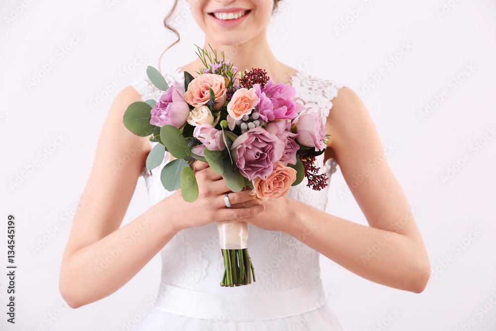 Fototapeta premium Bride holding wedding bouquet on white background, closeup