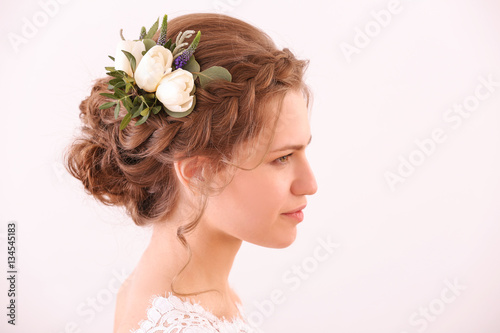 Young bride with beautiful hairstyle on white background