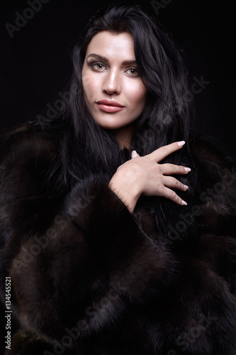 Portrait of a young brunette woman with long black hair dressed