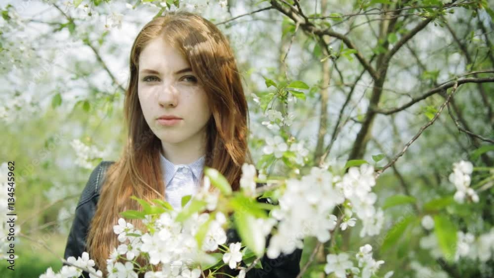 Redhead girl in blooming flowers Redhead girl in blooming flowers