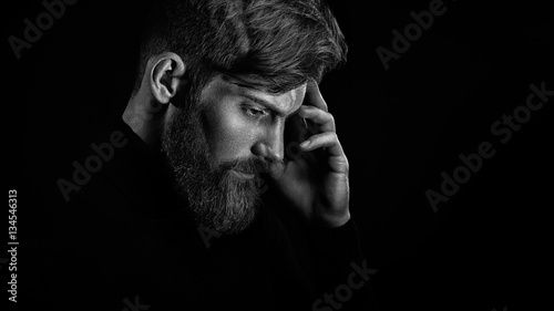 Young handsome bearded man with beard and stylish haircut think