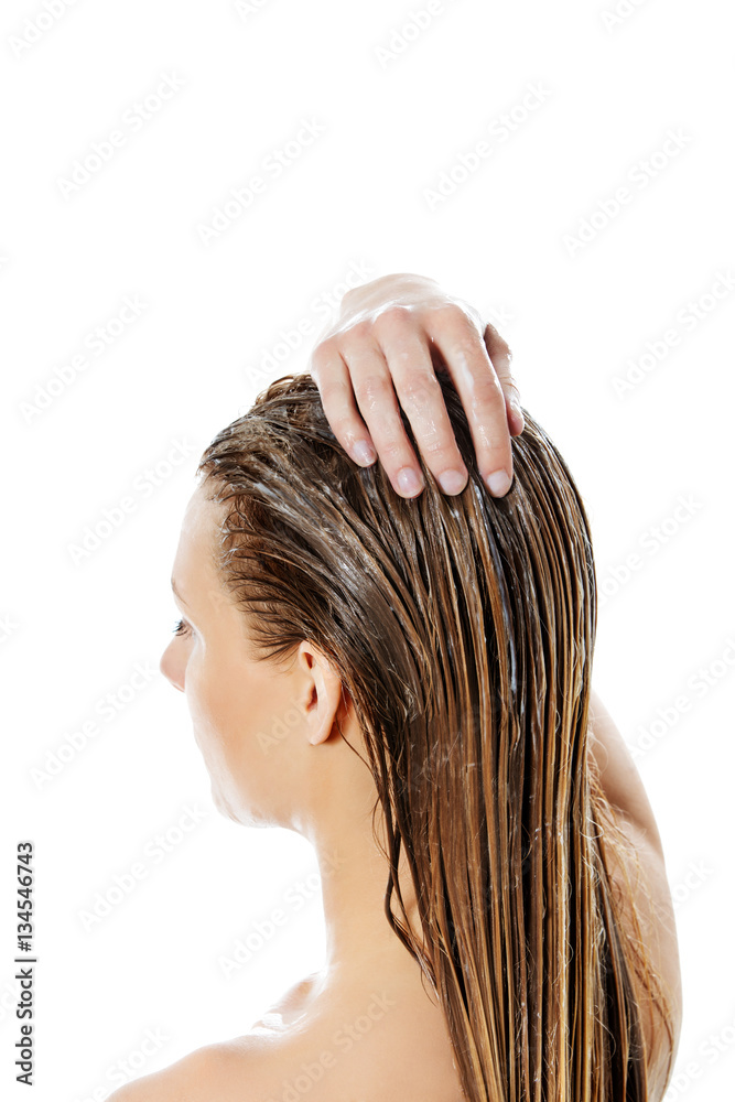 Naklejka premium Photo of woman applying hair conditioner.