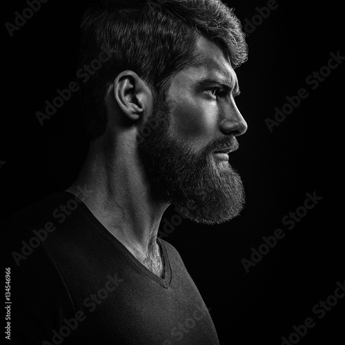 Black and white close-up portrait of young handsome bearded man