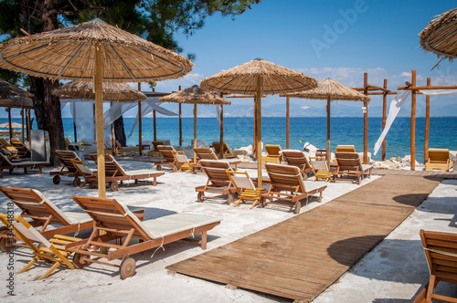 Beach with wooden umbrellas and sunbeds