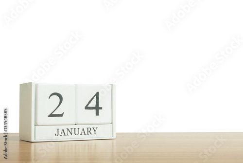 Closeup surface white wooden calendar with black 24 january word on blurred brown wood desk isolated on white background with copy space , selective focus at the calendar